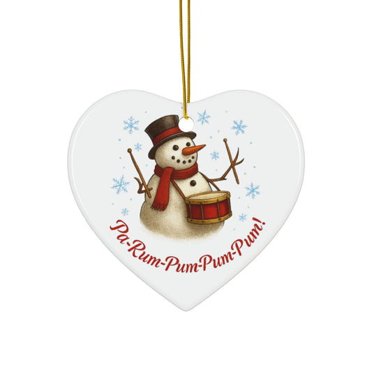 Heart-shaped Christmas ornament with a snowman playing a drum and the text 'Pa-Rum-Pum-Pum-Pum!' on a white background.